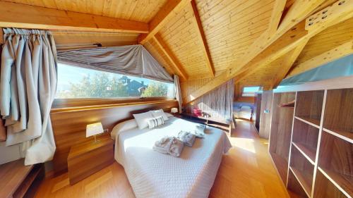 a bedroom with a bed and a large window at Apartaments Boutique la Torreta del Llac in Puigcerdà