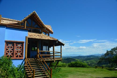 a house on a hill with a view of the mountains at Pousada Quinta da Serra in Cunha