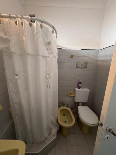a bathroom with a toilet and a shower curtain at La Casa de la Nona Elisa in Mar del Plata