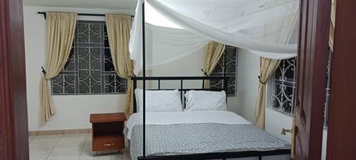 ein Schlafzimmer mit einem Himmelbett in der Unterkunft Mara Home 2 in Arusha