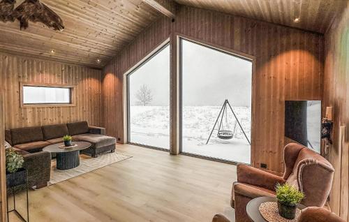 Åseralにある4 Bedroom Awesome Home In Åseralの木製の壁と大きな窓のあるリビングルーム