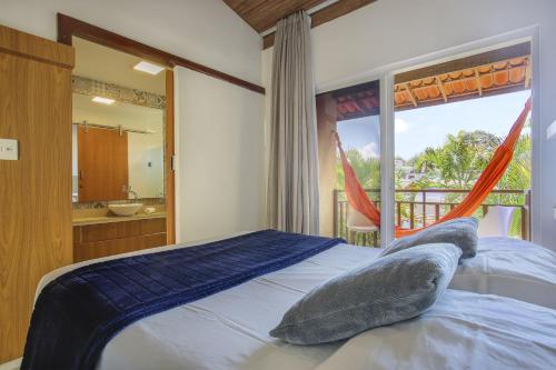 a bedroom with a bed and a large window at Flat Solar Água- by Pipa Praia House in Pipa