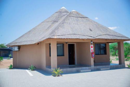 a small building with a thatched roof at Kuswani Hotel in Sebina