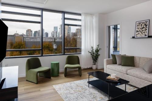 a living room with a couch and two green chairs at Smithe House in Vancouver