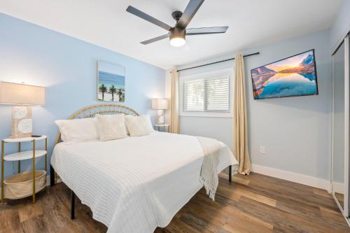 ココアビーチにあるThe Shark Tank Cocoa Beach - 2 2BR Units - 4BR Total - Each Unit Sleeps 5 - Walk to Beach & Downtownのベッドと天井扇風機のある寝室