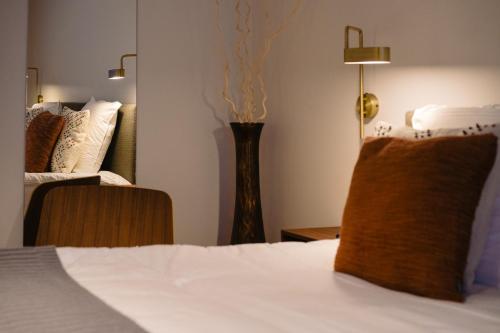 a bedroom with a bed and a vase on a table at Hotel du Bassin in Ostend