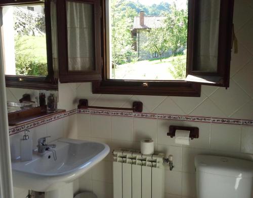 a bathroom with a sink and a toilet and a window at Apartamento Rural Rubó in Alles