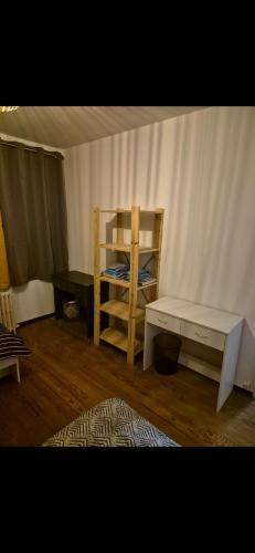 Cette chambre comprend un lit, une table et une étagère. dans l'établissement Chambre à louer, à Fécamp