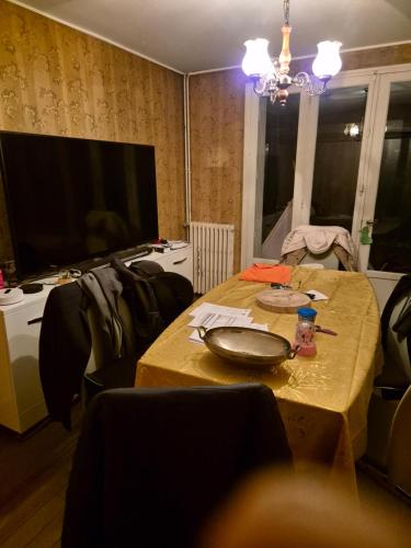 une table dans une pièce avec une télévision et une table avec un bol dans l'établissement Chambre à louer, à Fécamp