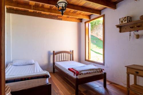 Katil atau katil-katil dalam bilik di Fazenda centenária com piscina e cachoeira