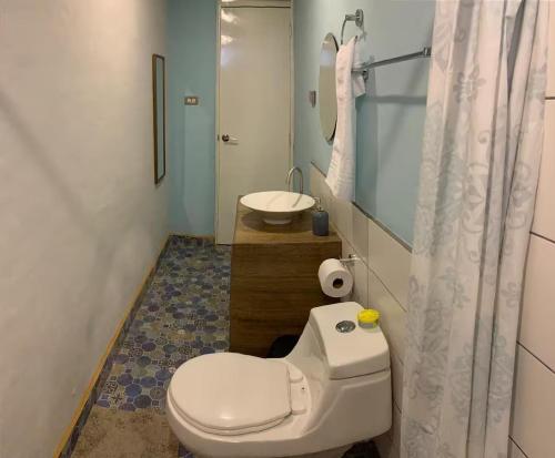 a bathroom with a white toilet and a sink at Runway 108 in Managua