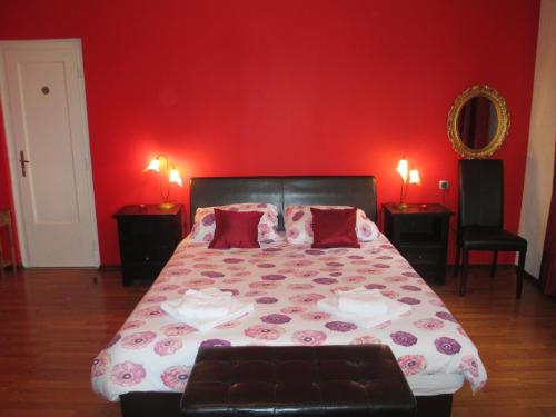 a bedroom with a bed with a red wall at Apartment Villa Edmea in Rijeka