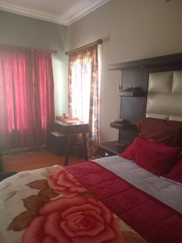 a bedroom with a bed with a rose on it at Town Charm Guesthouse in Germiston