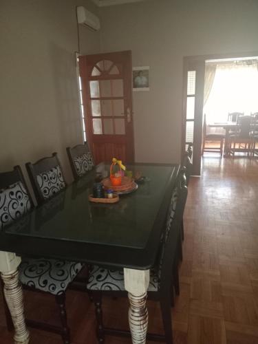 a dining room with a green table and chairs at Town Charm Guesthouse in Germiston