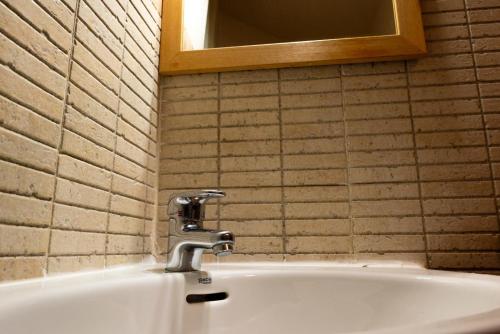 a bathroom sink with a faucet and a mirror at Pensión Discoves in Pinseque