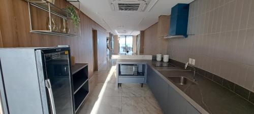a kitchen with a sink and a refrigerator at Parque do Cais - Flats Premium no Recife por Yolo in Recife