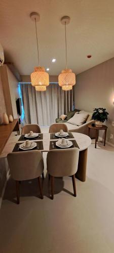 a living room with a table and chairs and a couch at Parque do Cais - Flats Premium no Recife por Yolo in Recife