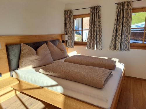 two beds in a room with two windows at Ferienwohnung Altrach in Aurach bei Kitzbuhel