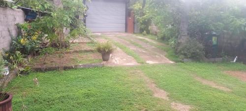 a yard with a house and a yard sidx sidx sidx at Light House Residence in Dondra West