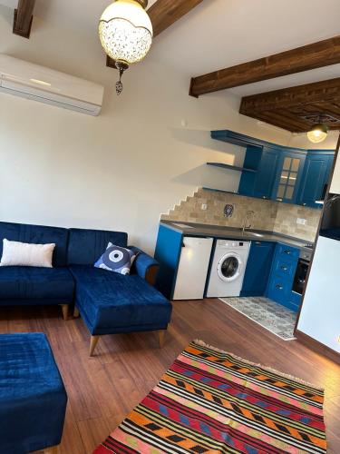 a living room with a blue couch and a kitchen at Saint Johns Hill Boutique Ephesus in Selcuk