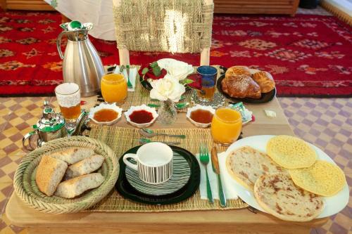 a table with a breakfast of bread and orange juice at riad dar wlidati in Marrakech