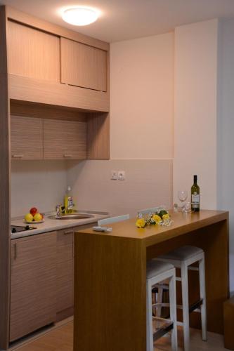 a kitchen with wooden cabinets and a counter top at Apartments Villa Splendor in Vrnjačka Banja