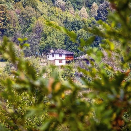 a house sitting in the middle of a mountain at Authentic House with Stunning Mountain View - Karashka in Apriltsi