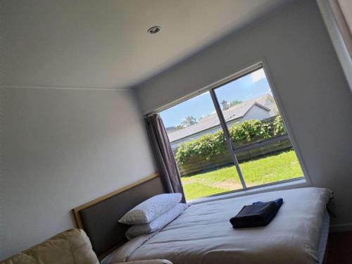Un dormitorio pequeño con una ventana grande y una cama. en Small 2-bedroom flat at Rangiatea Road, Epsom, Auckland, en Auckland
