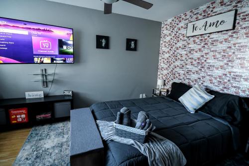 a bedroom with a black bed and a tv at Highrise DTWN 3 Bed Condo w King Bed in Atlanta