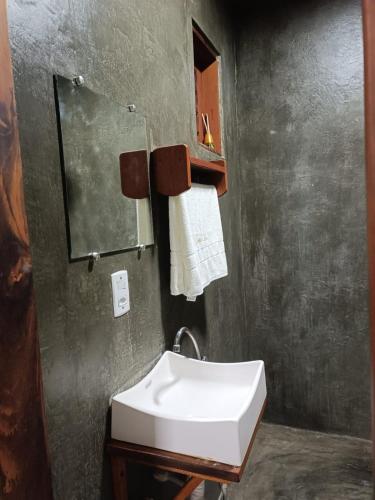 a bathroom with a white sink and a mirror at Chales Villa assu in Amontada