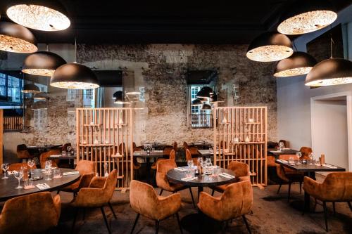 a restaurant with tables and chairs and chandeliers at InterContinental Marseille - Hotel Dieu by IHG in Marseille