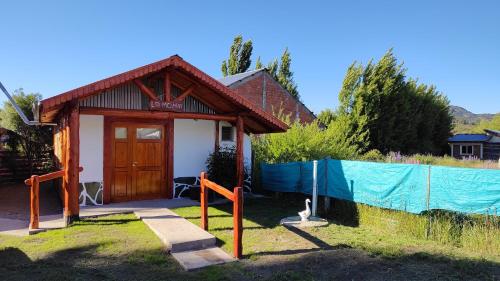 a small building with a fence in front of it at La Momia in Cholila