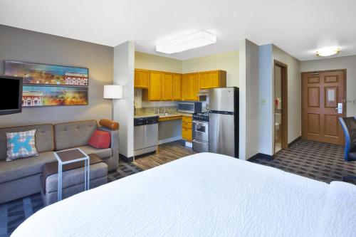 a hotel room with a bed and a kitchen at TownePlace Suites by Marriott Brookfield in Brookfield