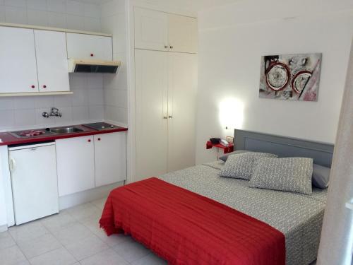 een kleine slaapkamer met een bed met een rode deken bij Ponderosa Holiday Studio 701 in Playa de las Americas