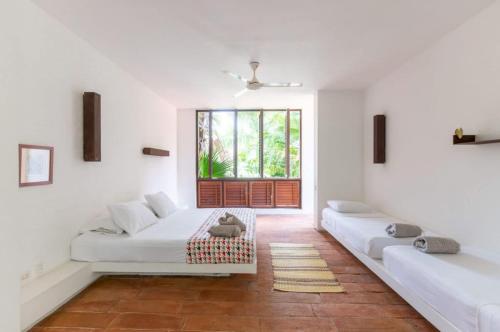 a white room with two beds and a window at Astonishing 5BR Villa at Mesa de Yeguas in Anapoima