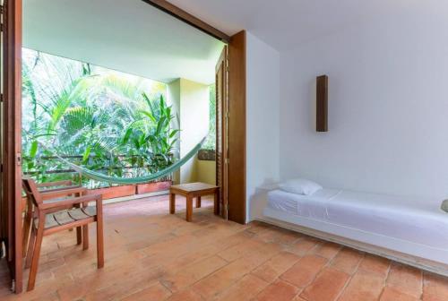 a bedroom with a bed and a chair and a window at Astonishing 5BR Villa at Mesa de Yeguas in Anapoima