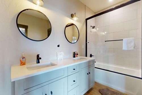 a bathroom with two sinks and a shower with mirrors at Mountain Bliss Retreat in Granby in Granby
