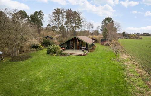 a large green yard with a cabin in the middle of a field at 3 Bedroom Beautiful Home In Hundested in Hundested