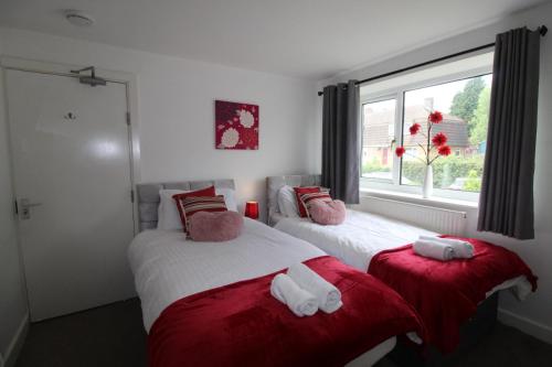 two beds in a room with a window at Hady House in Chesterfield