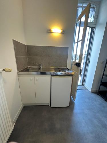une cuisine avec un évier et un plan de travail dans l'établissement Petit Studio Gare SNCF, à Tarbes
