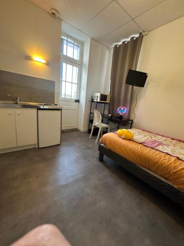 Cette chambre comprend un lit, un bureau et une cuisine. dans l'établissement Petit Studio Gare SNCF, à Tarbes