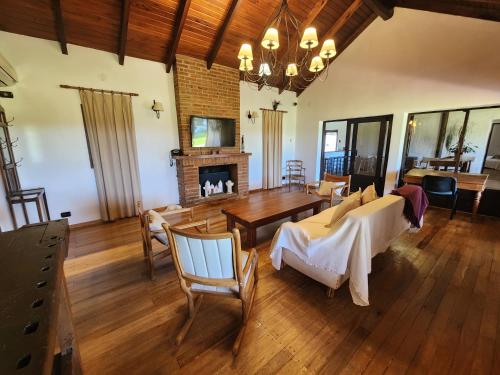 a living room with a table and a fireplace at Casa Chalet de Campo Lujosa con pileta Cerca de termas in Federación