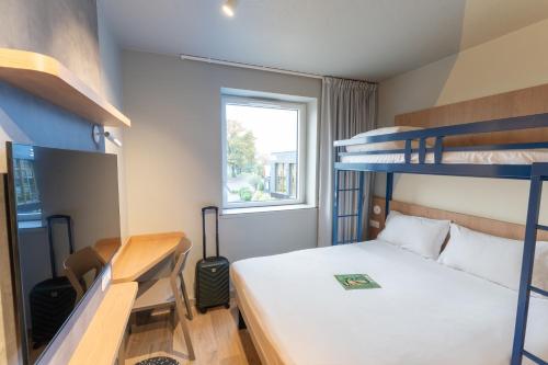 a small room with a bed and two bunk beds at Hotel Ibis Budget Rennes Cesson in Cesson-Sévigné