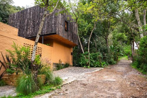 a house with a black roof and a dirt road at Casa Patio - Habitacion 6 in Los Reyes