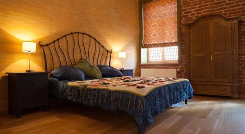 a bed in a room with a brick wall at Luxury Kaunas Old Town Apartment in Kaunas