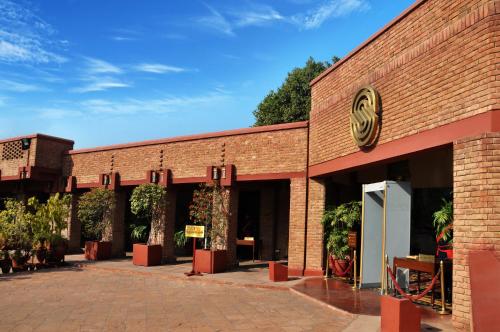 a brick building with a sign on the side of it at Faisalabad Serena Hotel in Faisalabad