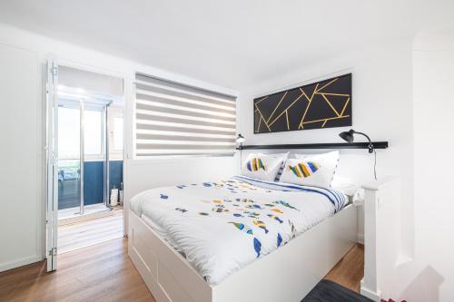 une chambre blanche avec un lit et une fenêtre dans l'établissement ASTORIA - Magnifique duplex lumineux à 100m des plages, à Menton