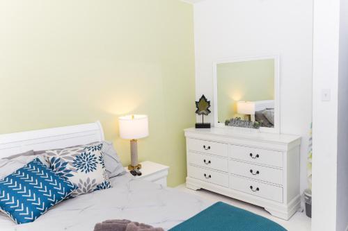 a bedroom with a white bed with a dresser and a mirror at Casa Marino - RELAX just minutes from Beaches in Llanos Tuna