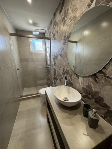 a bathroom with a sink and a mirror at Artemis Apartments in Diakopto