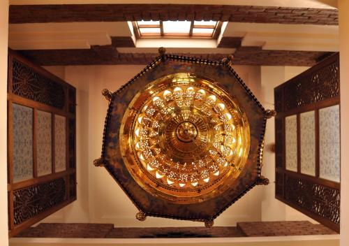 a large gold chandelier in a room with windows at Faisalabad Serena Hotel in Faisalabad